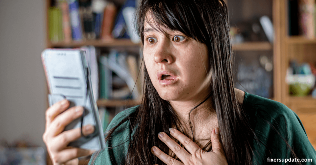 Cybersecurity threats - A woman intently looks at her phone, holding it in one hand as she engages with the screen.